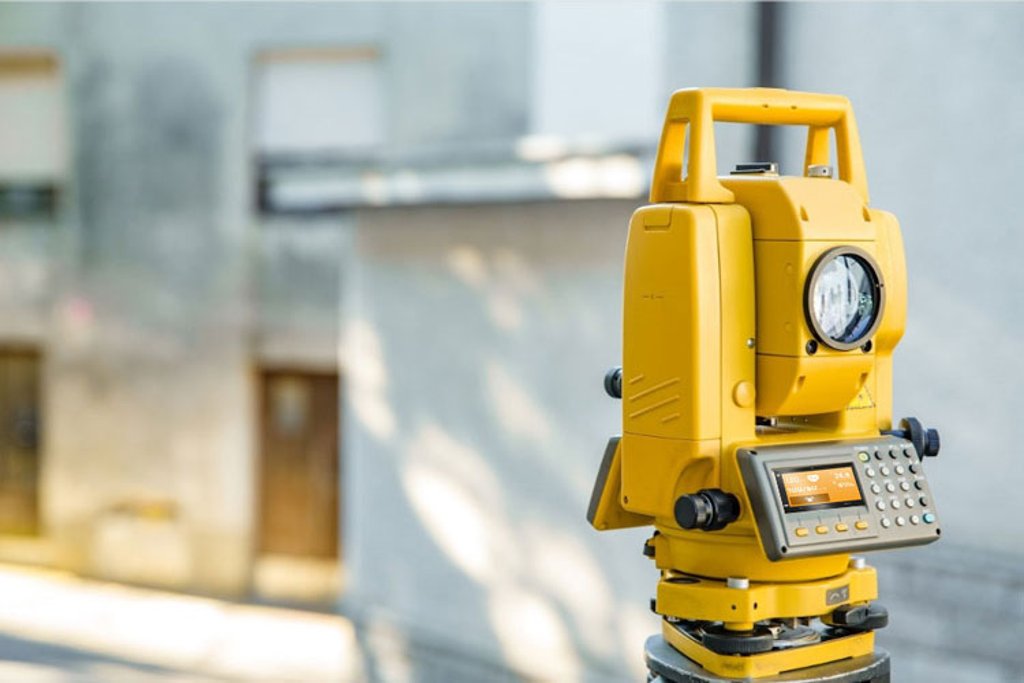 Yellow surveying equipment in an urban environment with blurred background